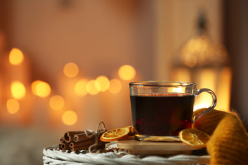 Cup of coffee on table against blurred lights, space for text. Cozy winter
