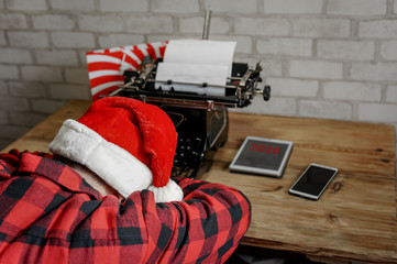 Santa Claus responds to letter of wishes on a typewriter. Front view of Santa Claus home