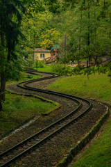 Narrow gauge railway in dark forest in rainy dark day