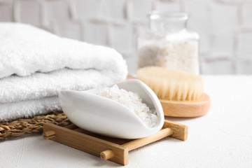 Fototapeta na wymiar Sea salt for spa scrubbing procedure in bowl on white table