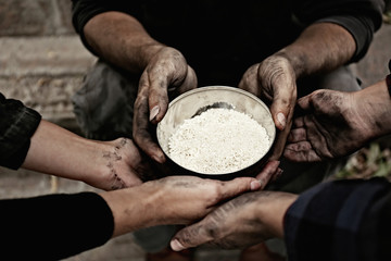 Poor homeless people with bowl of rice outdoors, closeup
