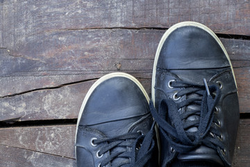 black women's leather sneakers on a wooden board from above, sports style
