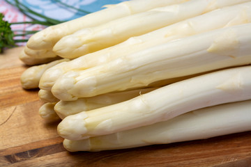 Bunch of fresh uncooked white asparagus and boiled eggs, new harvest