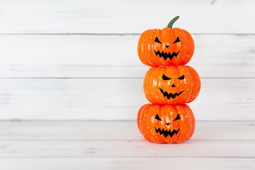 Stack of orange ghost pumpkin on white wood table with copy space ,  halloween concept.