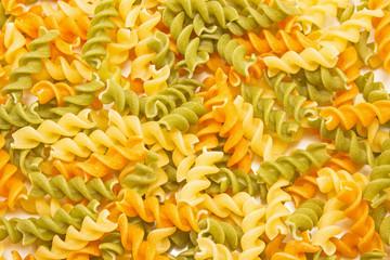 Fusilli tricolore raw dry pasta pile as background