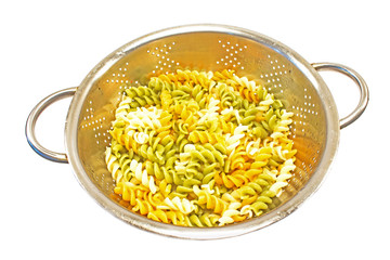 Cooked fusilli tricolore pasta in drain strainer isolated on white