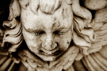Naklejka premium Death. Close up sad face of angel as symbol of pain, fear and end of life. Ancient sculpture.