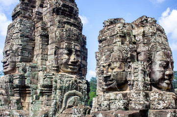 Fototapeta premium Siem Reap / Cambodia - May 27 / 2019 : huge buddha heads statues at bayon temple at angkor wat temple complex
