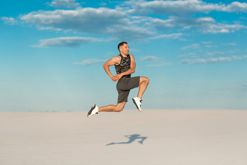 Fototapeta na wymiar Fitness man doing exercises in sand desert. Sport concept.