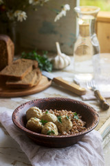 Meatballs in sour cream sauce, served with buckwheat porridge, bread and garlic. Rustic style.