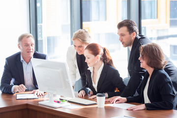 Business team look at one computer monitor