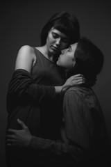 Young man and woman smooch each other. Black and white