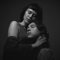 Young caucasian couple in love  on black background. Black and white