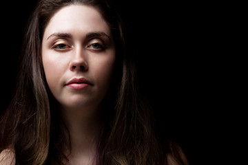 Fototapeta premium portrait of beautiful girl on black background with copy space