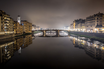 Fototapeta na wymiar Night view of the Arno river from the famous Ponte Vecchio. Florence, Tuscany, Italy