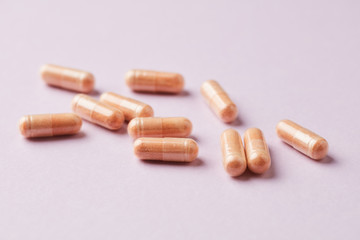 Goji Berry (Wolfberry) capsules. Immune system support. Dietary supplement on pink paper background. Close up. 