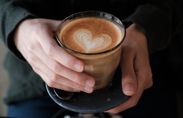 close up hand holding glass coffee 