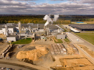 Wood processing plant pollutes the air with smoke coming from the pipe. Ecological problem of...