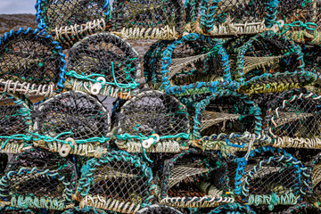 Lobster pots stacked on top of each other at a harbour in the Western Isles