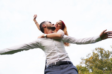 trait of excited funny funky two people look at sky space hold hand near eyes hug piggyback wear stylish trendy clothes. Happy couple piggybacking. 