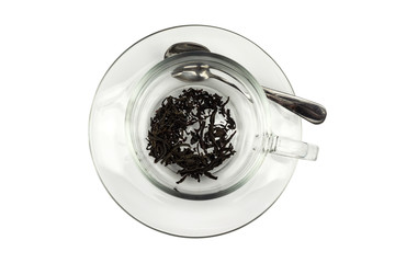 cup of dry tea in a transparent cup, tea leaves, isolated on white background
