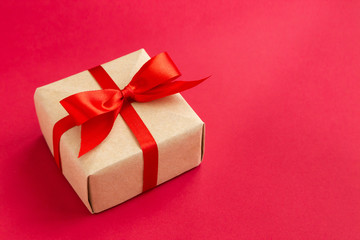 brown gift box with red ribbon on red background top view for christmas or celebrate