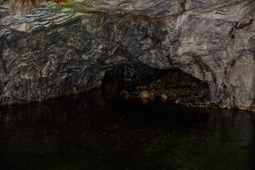 Underground Grotto Panorama.Types of a former underground marble quarry flooded with water. The massive arches of the grotto and the texture of natural marble are visible. Russia, Karelia, Ruskeala