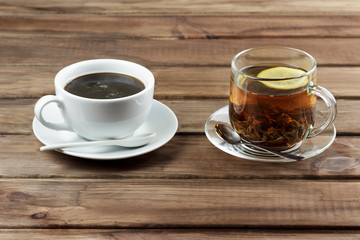cup of tea with lemon and a cup of coffee on a wooden surface, the choice between coffee and tea