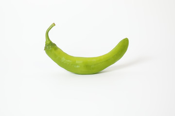 Green chili pepper on white background.