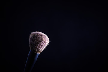 Makeup brush with pink on the black background