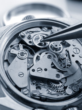 close up macro pic of vintage chronograph watch mechanism under repair by watchmaker