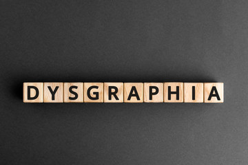 Dysgraphia - word from wooden blocks with letters, brain disease or damage, inability to write coherently, Dysgraphia concept, gray background