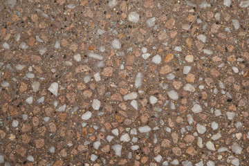 Gros plan texture béton désactivé avec graviers gris, noir et couleur rose