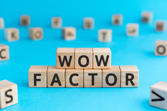 Wow factor - words from wooden blocks with letters, extremely impressive or attractive, wow factor concept, random letters around, blue background