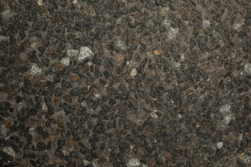 Gros plan texture béton désactivé avec graviers gris, noir et couleur