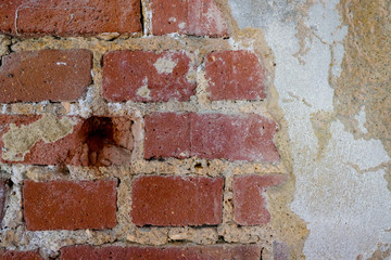 alte Backsteinmauer mit Bohrloch und Putz