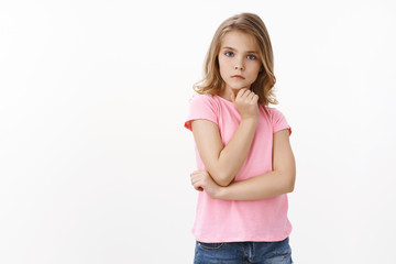 Smart good-looking clever little blong girl look serious and focused, carefully listen teacher,...