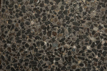 Gros plan texture béton désactivé avec graviers gris, noir et couleur