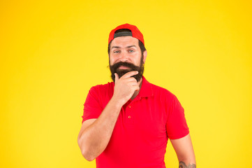 Nice thought. Salesman career. Hiring shop store worker. Hospitality staff. Supermarket staff wanted. Man thoughtful bearded hipster with mustache wear uniform yellow background. Shop staff concept