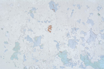 Light blue old concrete wall with partially peeling paint