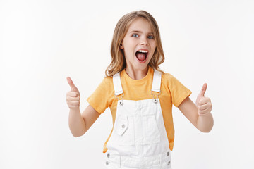 Energized motivated cute little rebellious blond girl support team, raise thumbs up approval, like awesome pool, spent cool summer holidas, shout yeah upbeat, rejoicing receive good gift