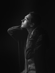 Portrait of young man in studio. Black and white. Profile