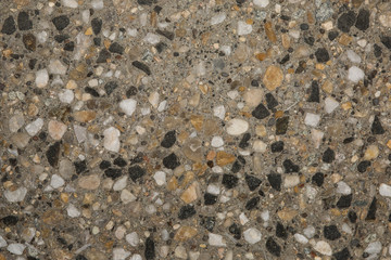 Gros plan texture béton désactivé avec graviers gris, noir et couleur
