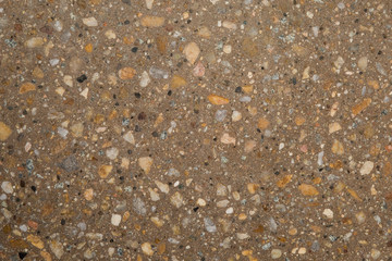 Gros plan texture béton désactivé avec graviers gris, noir et couleur