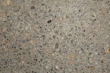 Gros plan texture béton désactivé avec graviers gris, noir et couleur