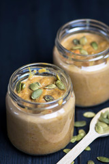 pumpkin puree soup with pumpkin seeds in a glass jar