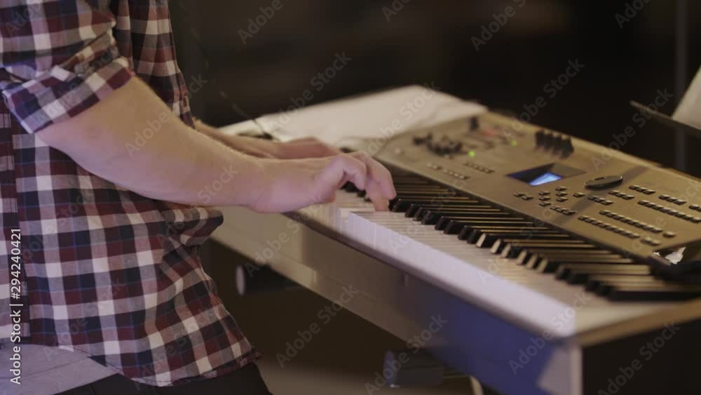 Poster medium close up of a piano player playing a keyboard enthusiastically.