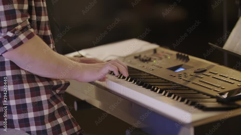 Poster medium close up of a piano player playing a keyboard enthusiastically.