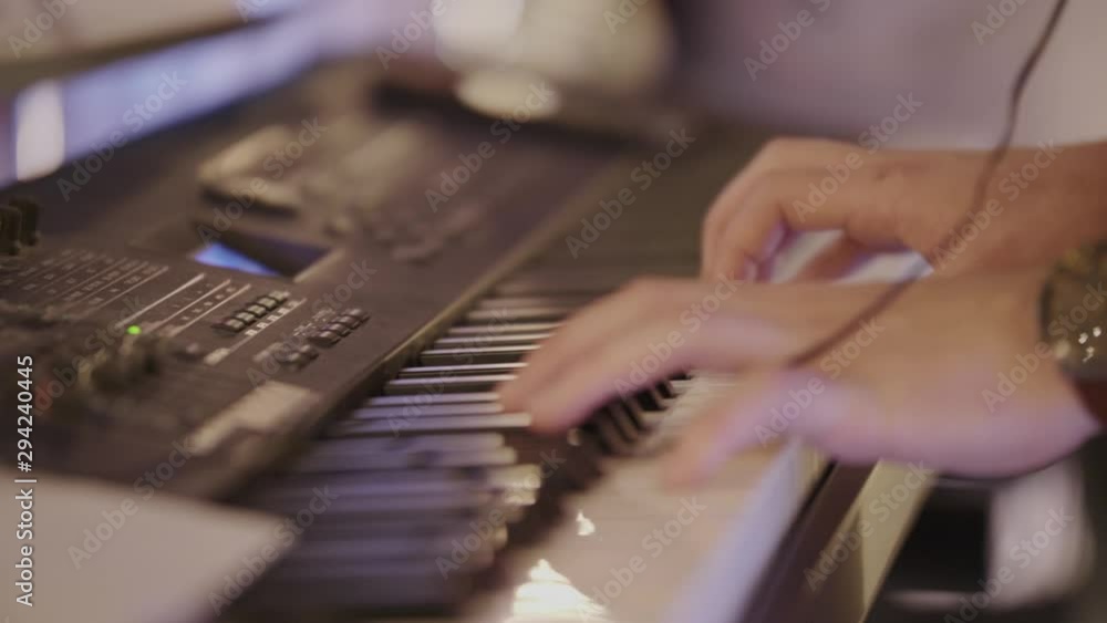 Poster close up of a piano player playing a keyboard enthusiastically.