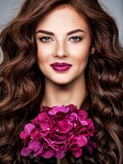 Fototapeta na wymiar Beautiful woman with long curly hair and purple make-up.
